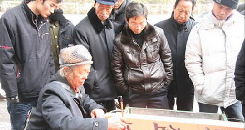 街头泼墨书法变钱 贴春联讨吉庆汽车也来凑热闹