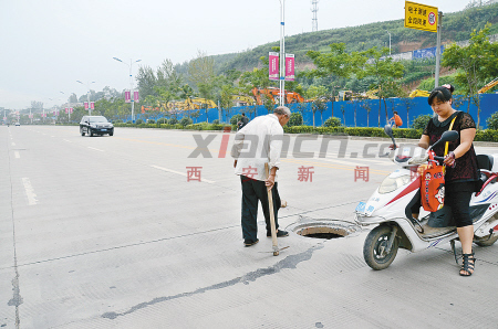 热心人商洛市区停车挡井口提醒路人绕行