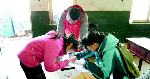 志愿者为困学生发放爱心助学金和御寒衣物