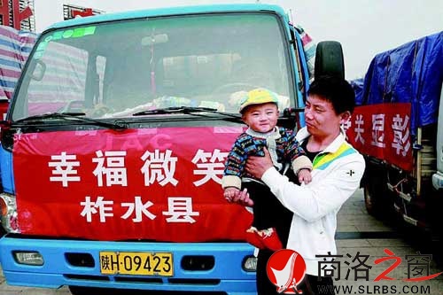父子俩远道而来，他们正在期待着爱心奶粉的发放。