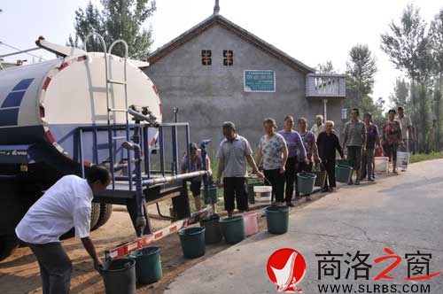 图为洛南县群众在接水