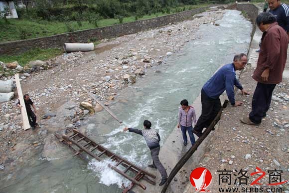 简易滑索拆除后,村民把木梯子横在河上过河上