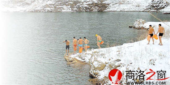 冬泳爱好者冒着严寒踩着积雪准备下水游泳