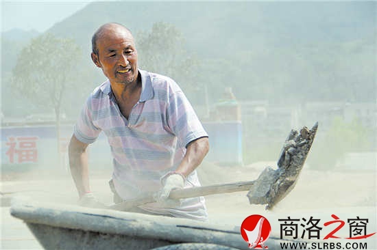 15点12分,来自商州区大赵峪办事处的村民刘捆柱正在比亚迪大道上清运沙石。虽然已经满头大汗,但他仍然奋力地挥舞着铁锨。