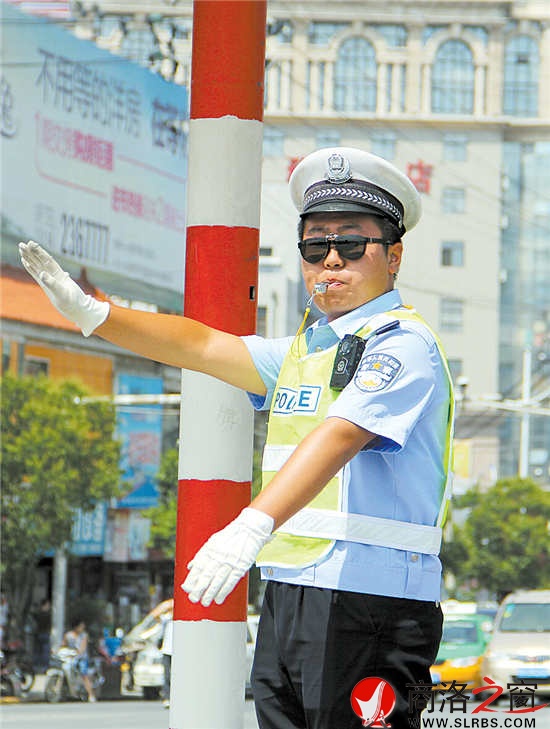 14点21分,19岁的马国威冒着酷暑在市区指挥交通。从下午一点半接班一直到晚上七点半,他与另外两名同事每隔一个小时轮换一次。