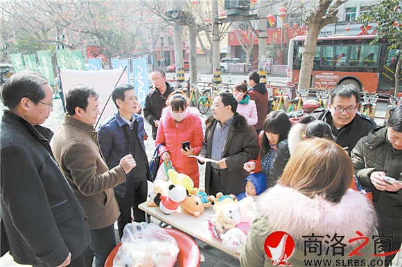 元宵节当天,报社领导走上街头为安装“掌中商洛”的读者发放礼品。