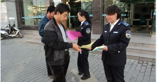 市城管监察支队执法人员走上街头散发传单