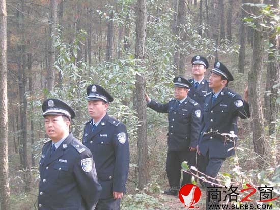郑安民（左一）带领民警在林区勘察