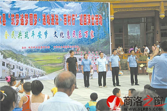 图为柞水县“送法送戏百村行”活动中“三官一律”上台与群众进行互动现场