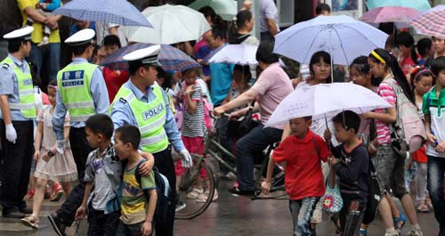 镇安县交警冒雨护送学生