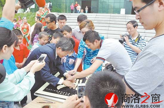 王锋在牛背梁景区用麦秆现场作画引起游客的浓厚兴趣