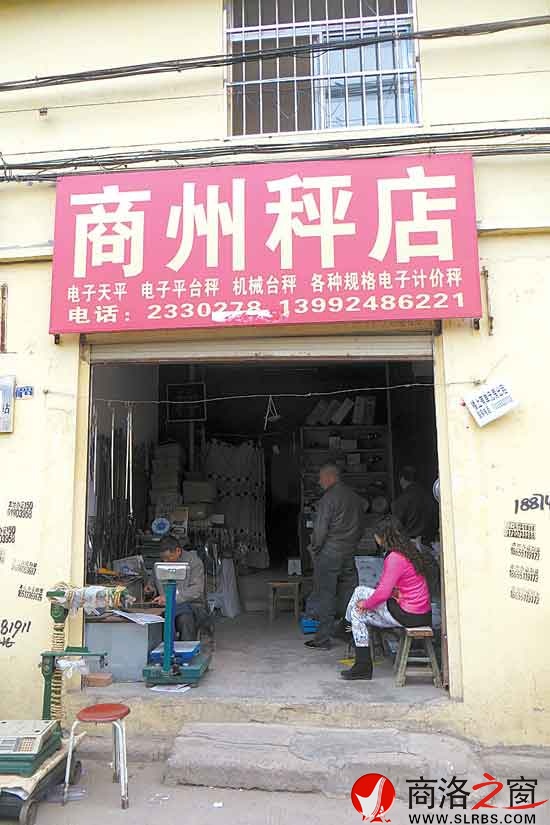 李宝曹专心致志地量秤杆的刻度