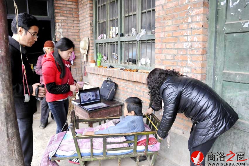 残联工作人员在专家的指导下为李飞飞定制轮椅