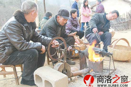 李子成在打爆米花中，和老年人一起回忆童年美好记忆。