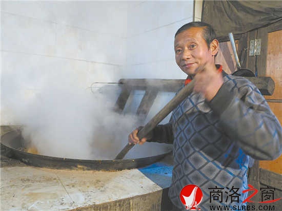 刘忠亮正在搅拌大锅里的糖稀
