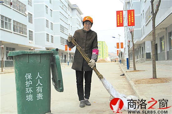 武家芳在小区院子里打扫卫生,因为喜爱这份工作,她连扫地时都带着微笑。