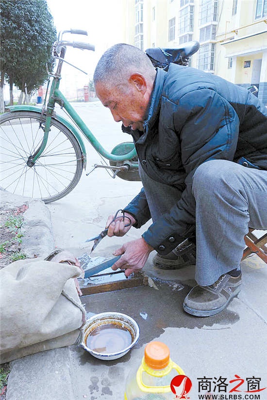 磨刀匠王养灵正在给群众磨剪刀