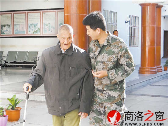 在山阳县荣军院里，张山怀老人和前来看望他的商洛军分区年轻战士交谈。