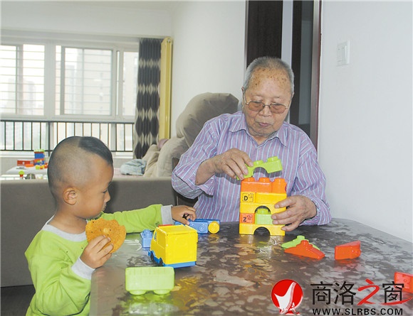 如今，老人对自己的生活很满足，他常常陪着孙子玩积木。