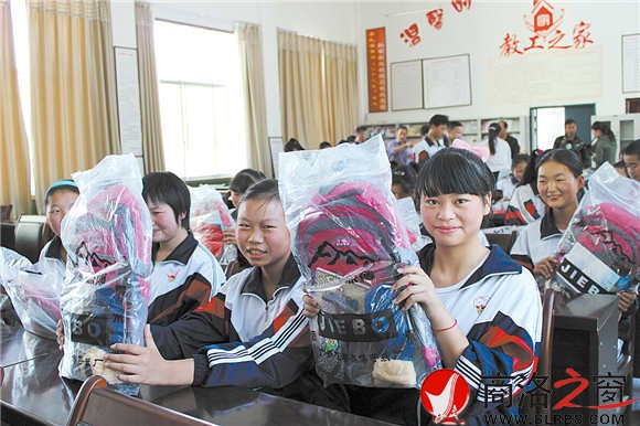 领到志愿者送来的爱心大礼包，孩子们幸福地笑了。