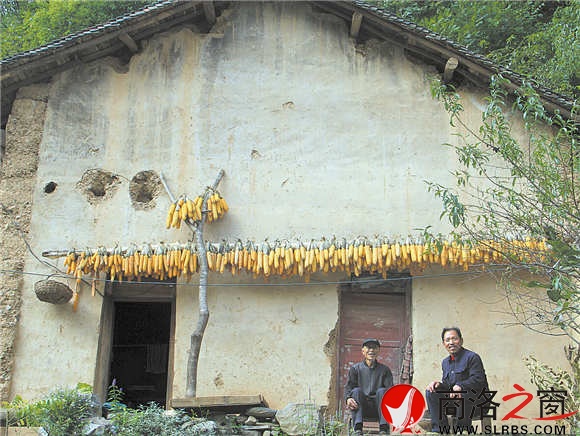 老人和他的邻居坐在家门口,幸福地谈论着如今的好生活