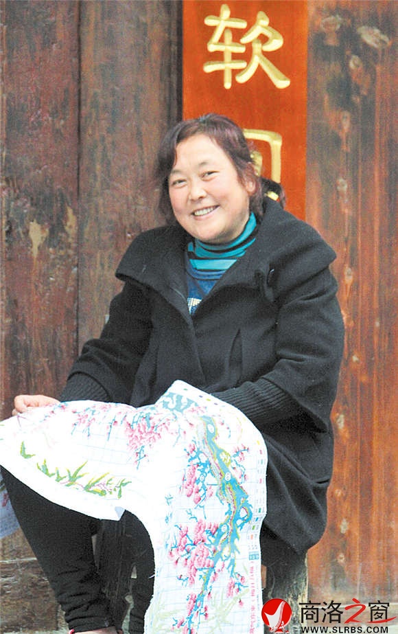 常道珍对自己生长的这片土地非常热爱，坐在老街的家门口绣十字绣，笑容始终挂在脸上。