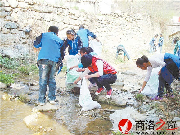 回龙中学的绿色小喇叭正在捡拾河边垃圾